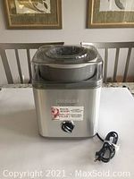 Front view of stainless steel Cuisinart frozen yogurt and ice cream maker with power cord coiled beside it