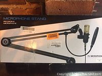 Box showing product image and description of a microphone stand arm for recording microphone.