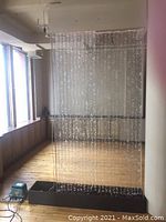 Full view of assembled bubble wall showing acrylic panel suspended above base with pump and lighting cables