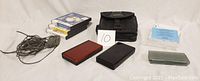 Overview of lot showing both Nintendo DS consoles, game cases, carrying bag, chargers, and instruction manual.