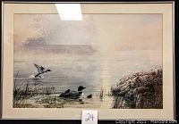 Framed print in silver metal frame with cream mat, depicting loons on a misty lake at sunrise