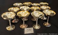 Twelve silver plate over copper goblets arranged in a cluster, showing front and top views.
