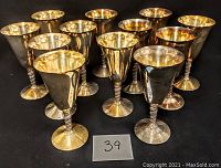 Group photo showing 12 Primrose Plate silverplate over copper wine goblets arranged in rows on a black surface.
