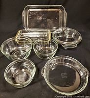 Overall set of Pyrex and Anchor Hocking glass bakeware arranged on black background showing all items together
