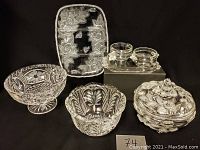 Photo showing six crystal items against black background including a small cut crystal dish, pedestal cut dish, covered candy dish, divided tray, and cream and sugar set with tray.