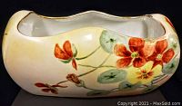 Front side view of antique Limoges porcelain dish showing floral hand-painted decoration with red and yellow flowers and green leaves.