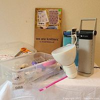 Photo showing the OttLite clip-on lamp, packages of zippers, and a plastic container with various pins and needles.