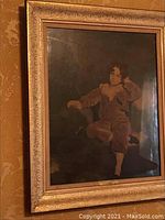 Framed portrait artwork showing a young man seated in traditional attire with gold painted wood frame.