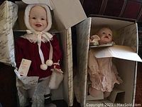 Photo shows Shirley Temple doll in red velvet outfit with white faux fur trim and bonnet inside original box