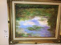 Frontal view of the framed oil painting showing water lilies and reflective water with green and blue tones.