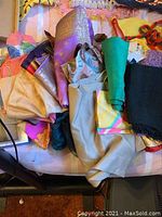 Photo of assorted vintage scarves in various colors and materials like nylon, silk, and cotton arranged in a pile showing different hues and textures.