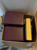 Top view of two maroon holders filled with magazines and visible yellow magazine spines