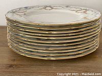 Stack of twelve Royal Doulton Caldwell salad plates showing gold gilt edges and scalloped rims.