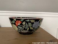 Side profile image of the large black ceramic bowl with colorful hand painted peonies and phoenix design.