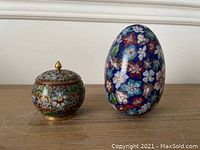 Jar and egg side by side showing their relative sizes and colorful floral patterns.