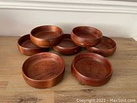 Seven solid wood bowls arranged in two rows, showing size and shape.