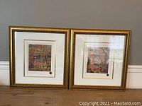 Pair of framed Tom Thomson prints with autumn trees and water scenes in gold decorative frames with white mats