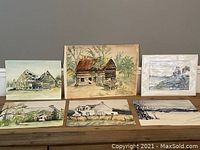 Wide shot of all six watercolor paintings showing rustic structures and landscapes.