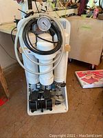 Front view showing plastic filter housings and hoses coiled around gauge