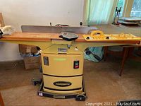 Front view of planer with wooden tables and rolling cart