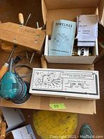 Top view photo showing Makita hand sander, two wooden clamps, DowelMax kit with instruction manuals, and Beall wood threader box.