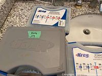 Gray Kreg Jig case and two blue Kreg branded plastic accessory cases on countertop.