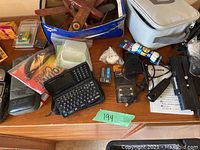 Photo of wooden model planes in blue box, assorted small items and camera parts on table
