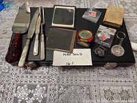 Full view of the entire lot on black case top on patterned surface