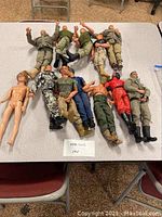 All GI Joe action figures arranged on a table showing various outfits and conditions