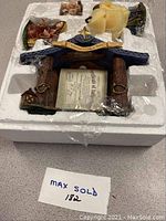 View of the rustic manger structure with star and text "O Holy Night" in packaging.