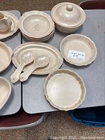 Photo showing plates, ladle-style serving spoons, covered serving bowl, and a scalloped edge dish.