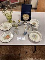 Photo of the assembled lot showing all plates, figurines, silver goblet, and glass vase
