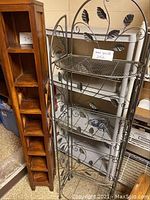 Two shelving units side by side: wooden bookshelf with multiple cubby holes and metal leaf-patterned shelving unit with mesh shelves
