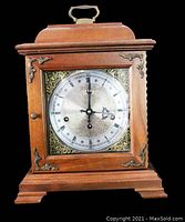 Front view of the vintage Hamilton mantel clock with walnut wood case and bronze decorative accents.