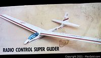 Photo of box top showing the white radio control super glider model with red and gray stripes and clear cockpit canopy, labeled as radio control super glider.