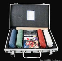 Open carrying case with poker chips in blue, green, red, white and black colors, stacked neatly. Includes deck of cards, dealer button, and small metal box. Foam padding inside the case holds items securely.