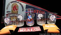 Photo of sports memorabilia including 2007 Boston Red Sox World Series pennant, five NFL-themed drinking glasses, yellow N.H.L. koozies, and thank you stickers.