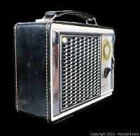 Side view of vintage General Electric transistor radio with metal speaker grille and leather case with handle on top.