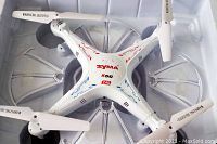 Top view of the white Syma X5C quadcopter drone showing propellers and red-blue detailing on the drone body.