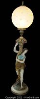 Full view of floor lamp showing polychrome painted figure and glass globe shade