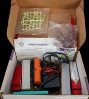 Top view of the box containing locomotives, cars, power supply, and accessories with instruction sheets visible