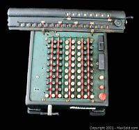 Top view of vintage Monroe manual calculator showing six columns of numbered circular keys, red vertical bars, and two large black buttons on upper right side.