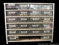 Front view of the metal cabinet showing 24 transparent plastic drawers with labels and visible contents of assorted electronic components inside.
