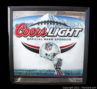 Front view of the framed Coors Light NFL wall hanging showing the logo, helmet, and mountain background.