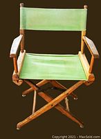 Front view of vintage marine folding director's chair with wooden frame and green canvas seat and backrest, suction cups on feet visible.