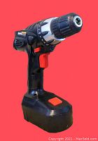 Front and side views of a black and red DrillMaster cordless drill with silver keyless chuck, battery attached at base.