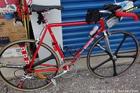 Side view of bicycle showing red Gardini frame, chrome fork, Aerospoke front wheel, rear wheel, saddle and handlebar configuration