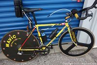 Full side view of yellow/red Colnago triathlon bike with disc and 3-spoke wheels