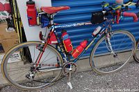 Right side view of steel lugged frame road bicycle with drop handlebars, water bottle cages, pump and saddle bag