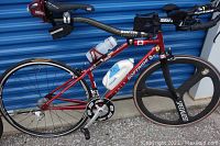 Full left side view of bike showing frame, wheels, bottles and saddle bag